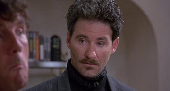 Movie still from “A Fish Called Wanda” (1988), directed by Charles Crichton – A person wearing a suit and tie; Close Up shot, Low angle