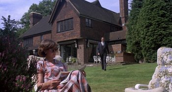 Movie still from “A Fish Called Wanda” (1988), directed by Charles Crichton – A woman sitting on the grass in front of a man; Wide shot, Low angle