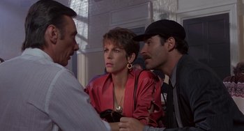 Movie still from “A Fish Called Wanda” (1988), directed by Charles Crichton – Two men and a woman are talking to each other; Medium shot, Over the shoulder angle