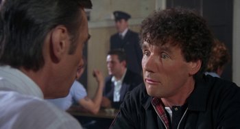 Movie still from “A Fish Called Wanda” (1988), directed by Charles Crichton – Two men sitting in front of each other in a room; Close Up shot, Over the shoulder angle