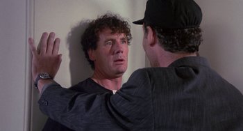 Movie still from “A Fish Called Wanda” (1988), directed by Charles Crichton – A man looking at another man in the mirror; Close Up shot, Over the shoulder angle