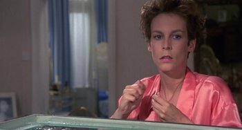 Movie still from “A Fish Called Wanda” (1988), directed by Charles Crichton – A woman in a pink shirt looking at her reflection in a mirror; Close Up shot, Over the shoulder angle