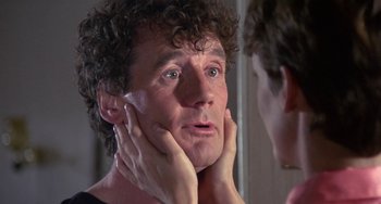 Movie still from “A Fish Called Wanda” (1988), directed by Charles Crichton – A man with curly hair looking in the mirror; Close Up shot, Over the shoulder angle