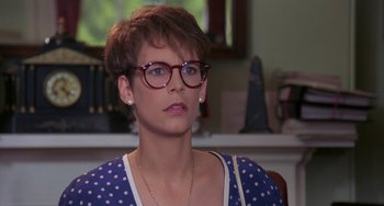 Movie still from “A Fish Called Wanda” (1988), directed by Charles Crichton – A woman wearing glasses and a polka dot shirt; Close Up shot, Over the shoulder angle