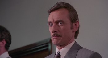 Movie still from “A Fish Called Wanda” (1988), directed by Charles Crichton – A person wearing a suit and tie; Close Up shot, Low angle