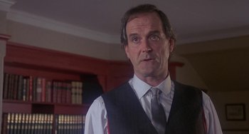 Movie still from “A Fish Called Wanda” (1988), directed by Charles Crichton – A person wearing a suit and tie; Close Up shot, Low angle
