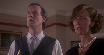 Movie still from “A Fish Called Wanda” (1988), directed by Charles Crichton – A man and a woman standing next to each other in a room; Close Up shot, Low angle