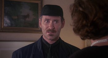 Movie still from “A Fish Called Wanda” (1988), directed by Charles Crichton – A person wearing a hat; Close Up shot, Over the shoulder angle