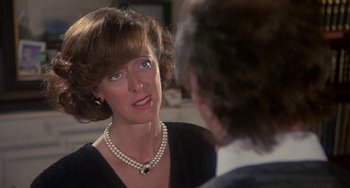 Movie still from “A Fish Called Wanda” (1988), directed by Charles Crichton – A woman wearing a pearl necklace talking to a man; Close Up shot, Over the shoulder angle