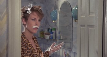 Movie still from “A Fish Called Wanda” (1988), directed by Charles Crichton – A woman in a leopard print shirt is in a bathroom; Close Up shot, Low angle