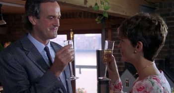 Movie still from “A Fish Called Wanda” (1988), directed by Charles Crichton – A man and a woman drinking wine at a party; Medium shot, Low angle