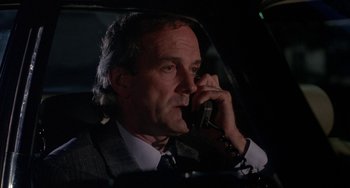 Movie still from “A Fish Called Wanda” (1988), directed by Charles Crichton – A person talking on a cell phone; Close Up shot, Low angle