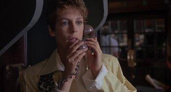 Movie still from “A Fish Called Wanda” (1988), directed by Charles Crichton – A woman holding a phone up to her face; Close Up shot, Low angle