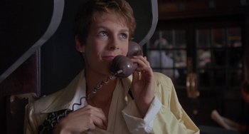 Movie still from “A Fish Called Wanda” (1988), directed by Charles Crichton – A woman holding a phone up to her ear; Close Up shot, Low angle