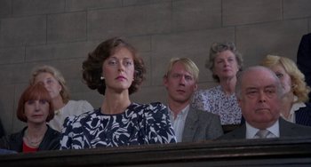 Movie still from “A Fish Called Wanda” (1988), directed by Charles Crichton – A woman and two men sitting in front of a wall; Close Up shot, Low angle