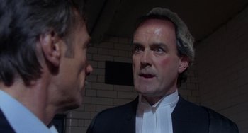 Movie still from “A Fish Called Wanda” (1988), directed by Charles Crichton – A man in a suit talking to another man in a suit; Close Up shot, Low angle