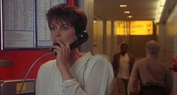 Movie still from “A Fish Called Wanda” (1988), directed by Charles Crichton – A woman talking on a phone while standing next to a wall; Close Up shot, Low angle