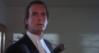 Movie still from “A Fish Called Wanda” (1988), directed by Charles Crichton – A person holding a baseball bat; Close Up shot, Low angle