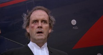Movie still from “A Fish Called Wanda” (1988), directed by Charles Crichton – A person wearing a suit and tie; Close Up shot, Low angle