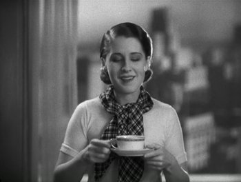Movie still from “A Free Soul” (1931), directed by Clarence Brown – A woman holding a cup of coffee in her hands; Medium shot, High angle