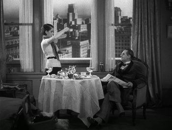 Movie still from “A Free Soul” (1931), directed by Clarence Brown – An old photo of a man and a woman sitting at a dinner table; Medium shot, High angle