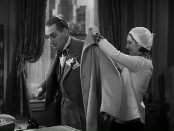 Movie still from “A Free Soul” (1931), directed by Clarence Brown – A man and a woman are fixing a suit; Medium shot, High angle