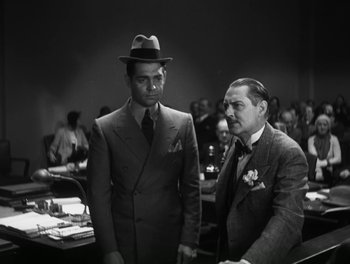 Movie still from “A Free Soul” (1931), directed by Clarence Brown – Two men standing next to each other in front of a crowd; Medium shot, Low angle