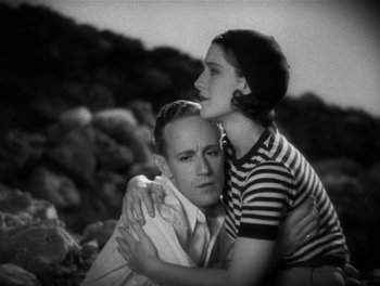 Movie still from “A Free Soul” (1931), directed by Clarence Brown – A man and a woman embracing each other in a black and white photo; Medium shot, High angle