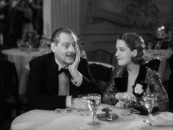 Movie still from “A Free Soul” (1931), directed by Clarence Brown – An older man sitting next to a young woman at a dinner table; Medium shot, High angle