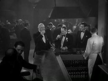 Movie still from “A Free Soul” (1931), directed by Clarence Brown – A black and white photo of men at a bar; Medium shot, High angle