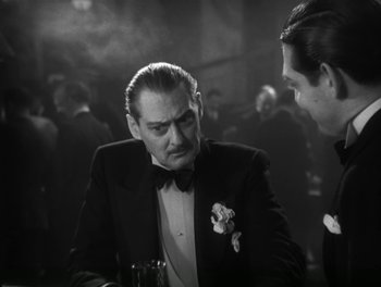Movie still from “A Free Soul” (1931), directed by Clarence Brown – A man in a tuxedo is talking to another man in a suit; Close Up shot, Over the shoulder angle