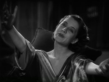 Movie still from “A Free Soul” (1931), directed by Clarence Brown – An old photo of a woman waving her hand; Medium shot, Low angle