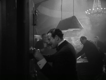 Movie still from “A Free Soul” (1931), directed by Clarence Brown – Black and white photograph of a man in a suit and tie; Medium shot, Low angle