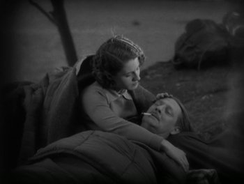 An old photo of a woman and a man laying on the ground