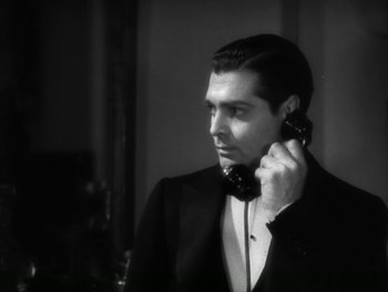 Movie still from “A Free Soul” (1931), directed by Clarence Brown – A black and white photo of a man talking on a phone; Close Up shot, High angle