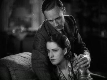 Movie still from “A Free Soul” (1931), directed by Clarence Brown – A man and a woman sitting on a couch together; Close Up shot, High angle