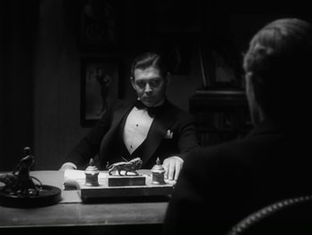 Movie still from “A Free Soul” (1931), directed by Clarence Brown – A man sitting at a table in front of a typewriter; Medium shot, High angle