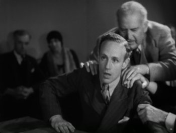 Movie still from “A Free Soul” (1931), directed by Clarence Brown – A man in a suit and tie with another man in a tie; Medium shot, High angle
