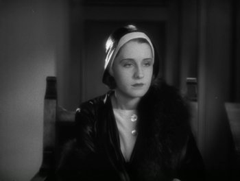 Movie still from “A Free Soul” (1931), directed by Clarence Brown – A woman wearing a hat sitting in a chair; Close Up shot, High angle