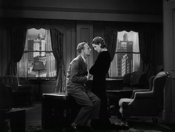 Movie still from “A Free Soul” (1931), directed by Clarence Brown – A man and a woman sitting in a living room next to each other; Medium shot, High angle