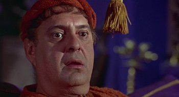Movie still from “A Funny Thing Happened on the Way to the Forum” (1966), directed by Richard Lester – A person wearing a hat with a tassle; Close Up shot, Low angle