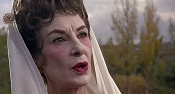 Movie still from “A Funny Thing Happened on the Way to the Forum” (1966), directed by Richard Lester – An older woman with a white veil on her head; Close Up shot, Low angle