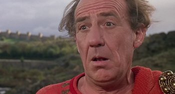Movie still from “A Funny Thing Happened on the Way to the Forum” (1966), directed by Richard Lester – An older man with a surprised look on his face; Close Up shot, Over the shoulder angle