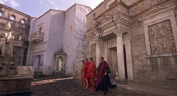 Movie still from “A Funny Thing Happened on the Way to the Forum” (1966), directed by Richard Lester – A group of people in ancient roman clothing walking down a street; Extreme Wide shot, Low angle