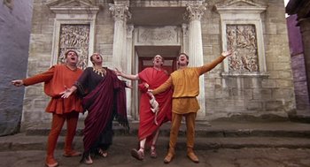 Movie still from “A Funny Thing Happened on the Way to the Forum” (1966), directed by Richard Lester – A group of people dressed in ancient roman clothing; Wide shot, Low angle