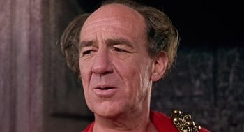 Movie still from “A Funny Thing Happened on the Way to the Forum” (1966), directed by Richard Lester – An older man with a bald head and a mustache; Close Up shot, Low angle