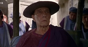 Movie still from “A Funny Thing Happened on the Way to the Forum” (1966), directed by Richard Lester – An older man wearing a hat and a purple robe; Close Up shot, Low angle
