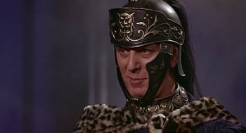 Movie still from “A Funny Thing Happened on the Way to the Forum” (1966), directed by Richard Lester – A man wearing a helmet and a leopard print jacket; Close Up shot, Over the shoulder angle