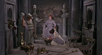 Movie still from “A Funny Thing Happened on the Way to the Forum” (1966), directed by Richard Lester – A group of people standing in a room with statues; Wide shot, High angle