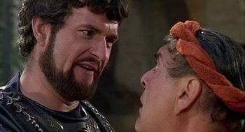 Movie still from “A Funny Thing Happened on the Way to the Forum” (1966), directed by Richard Lester – A man and a woman face each other in front of a brick wall; Close Up shot, Over the shoulder angle
